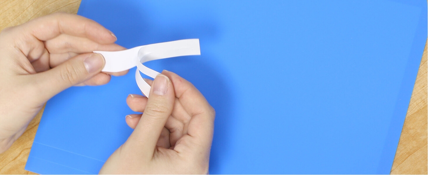 Person removing split backing to apply label