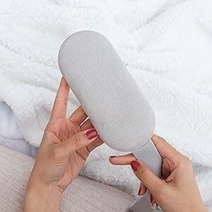 Women holding the heating pad and showing the back side of the pad