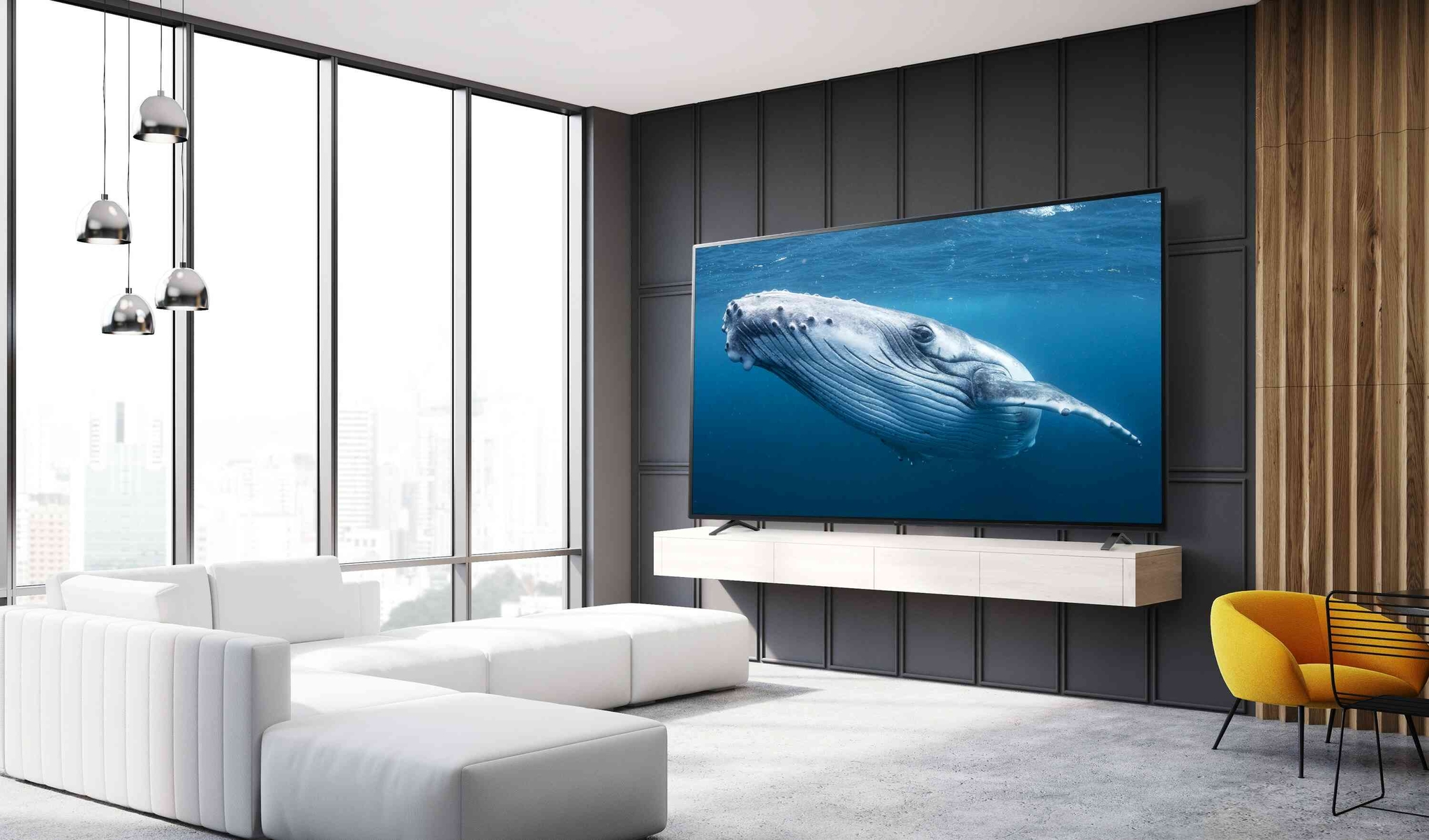 In a living room, there is a large screen TV displaying an image of a big whale in the sea.