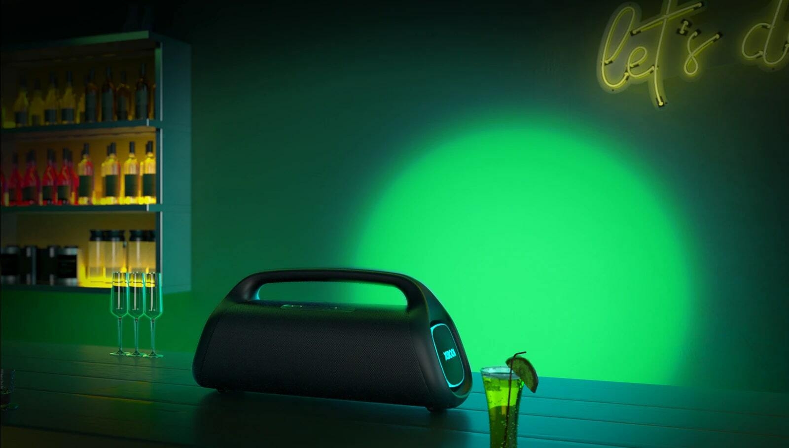 LG XBOOM Go XG9 is placed on the bar table. It casts a grenn and blue stage lighting.