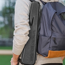 Venova in a hard case carried over the shoulder next to a backpack