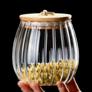 Elegant ribbed glass storage jar with a natural bamboo lid and gold-tone handle
